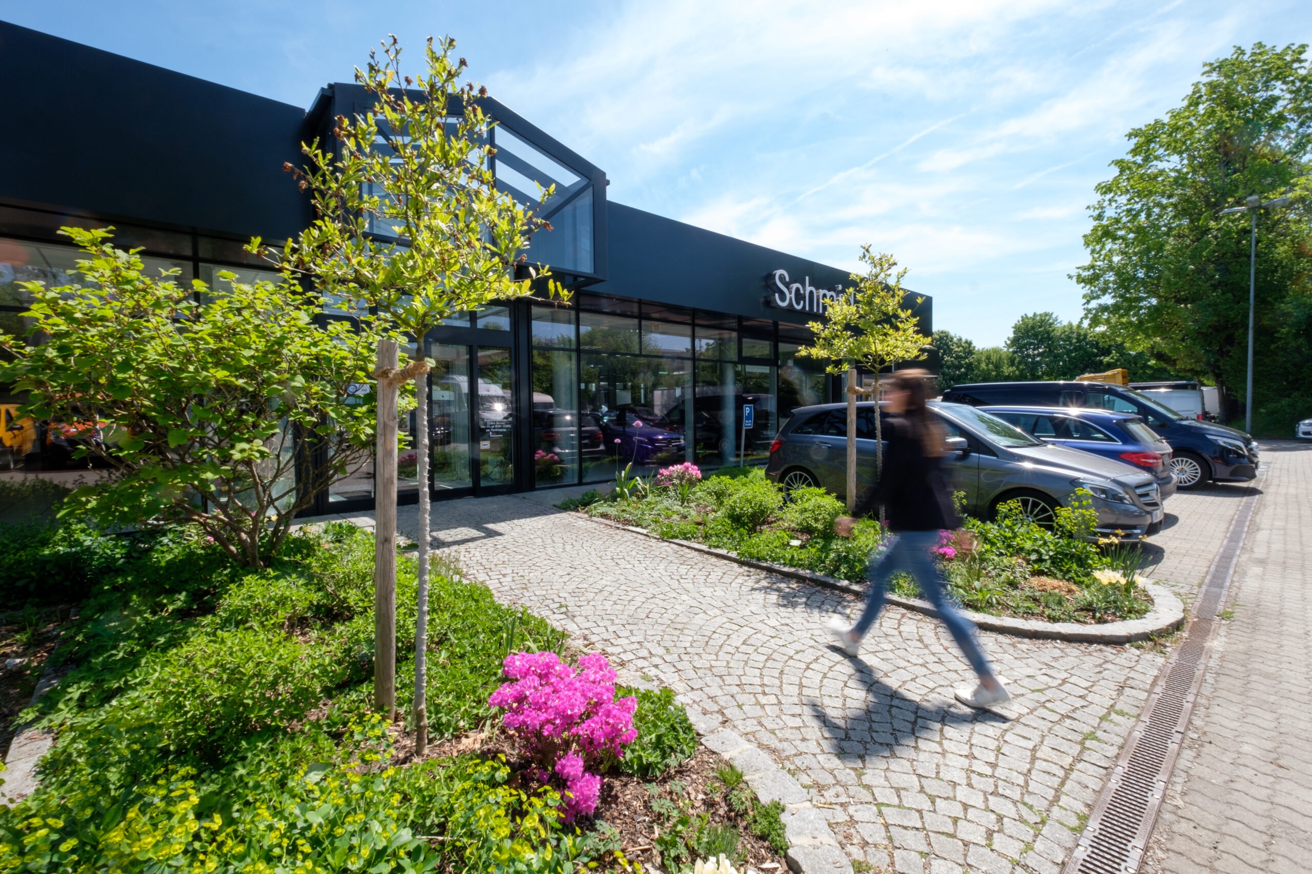 Außenansicht Autohaus Franz Schmid in Holzkirchen mit Glasfront, Eingangsbereich und Kundenparkplätzen