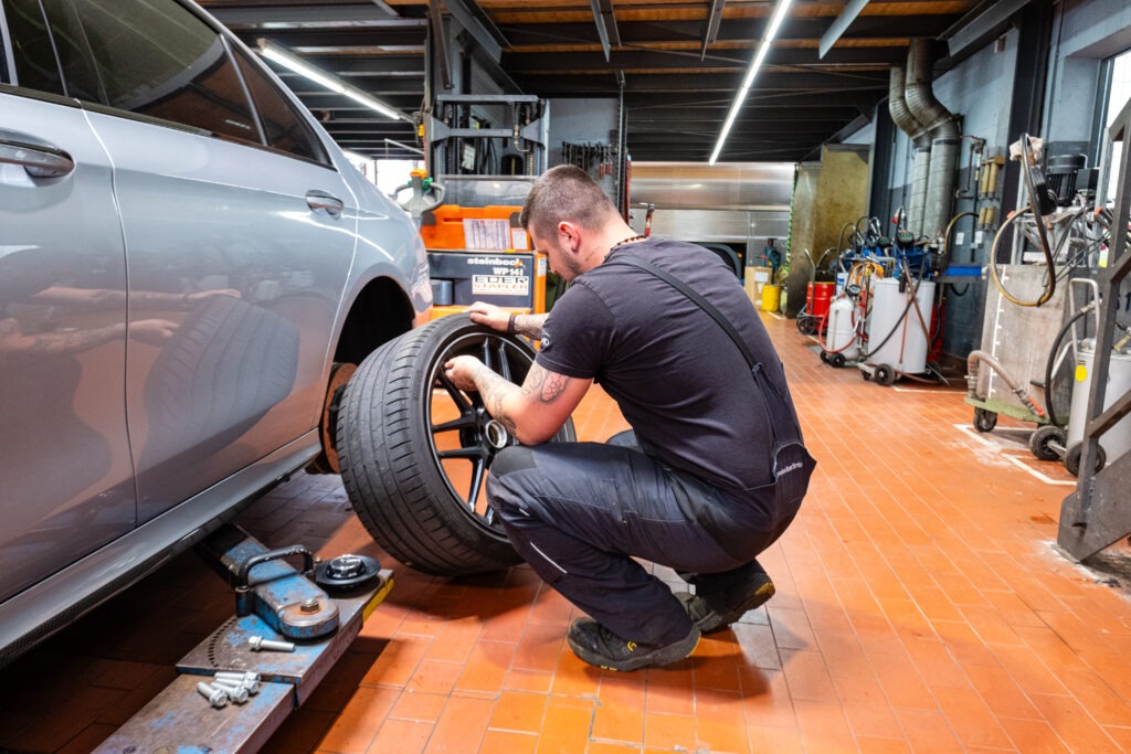 Servicetechniker montiert ein Rad in der Werkstatt von Autohaus Franz Schmid in Holzkirchen