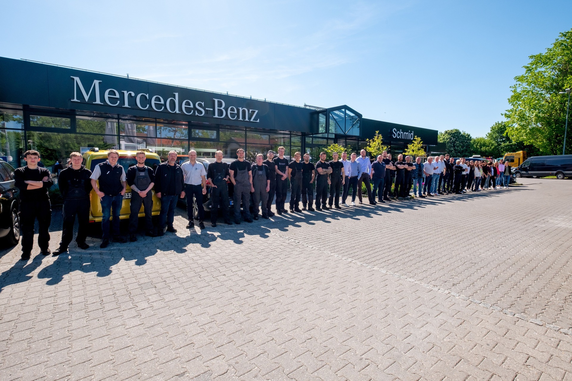 Gruppenfoto des Teams von Autohaus Franz Schmid vor dem Mercedes-Benz Autohausgebäude in Holzkirchen